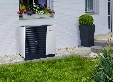 WĂ€rmepumpe SolvisMia vor Einfamilienhaus.